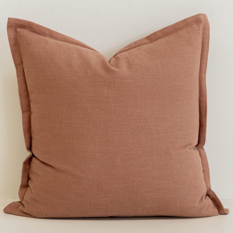 Close-up of Clay linen cushion in warm terracotta tone with soft texture.