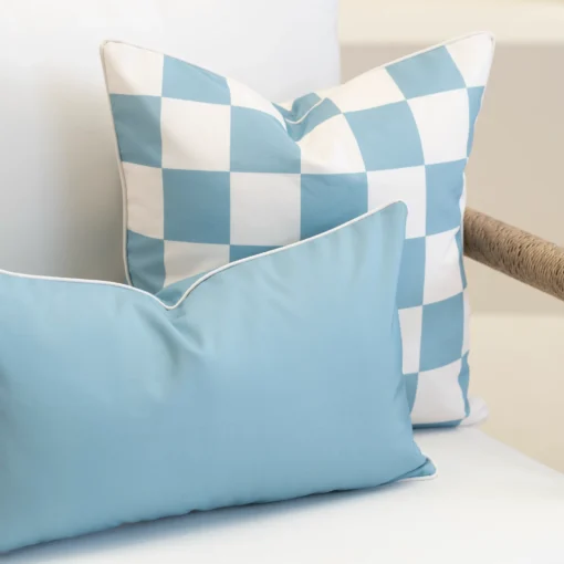 Close-up of Tropica aqua cushions with blue check pattern and plain cushion.