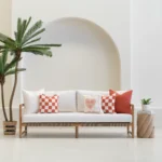 Tropica red outdoor cushions with checker and heart patterns on white sofa.