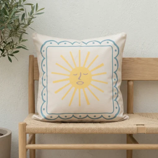 Tropica cushion with yellow sun motif and blue bordered frame on bench.