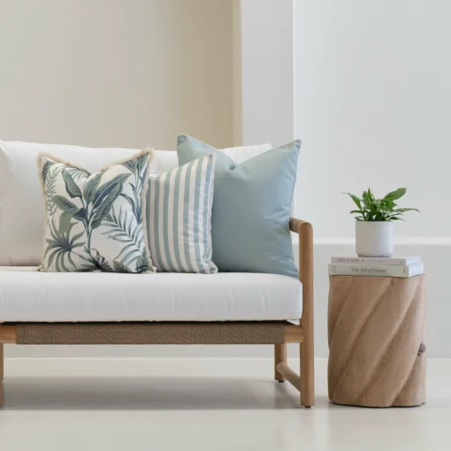 Wildgrove frond cushions with blue stripes and botanical prints on sofa.